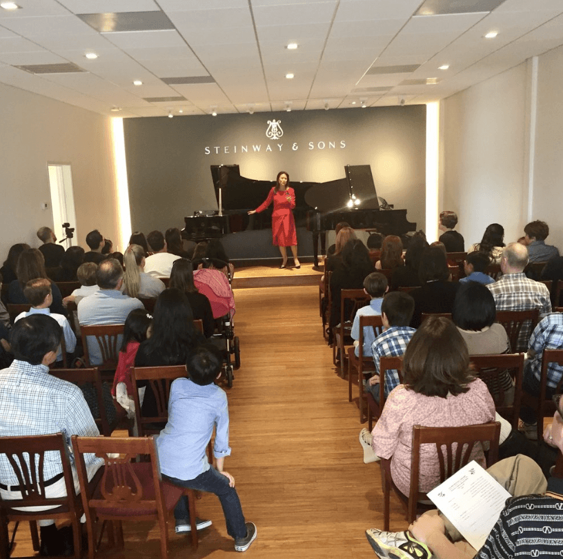Sue Zhou addressing the audience at a Steinway recital